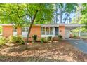 Charming brick home with a well-maintained lawn and mature tree in a quiet neighborhood at 903 W Maynard Ave, Durham, NC 27704