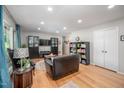 Spacious living room with hardwood floors, a comfortable sofa, and a wall-mounted TV at 903 W Maynard Ave, Durham, NC 27704