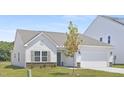 Single-Gathering home boasting a lush lawn, stone accents, and a convenient two-car garage at 94 Mable Court # 16, Lillington, NC 27546