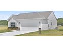 View of the home's exterior featuring a two-car garage, stone accents, and a well-maintained lawn at 94 Mable Court # 16, Lillington, NC 27546