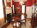 Formal dining room featuring a classic fireplace, chandelier, and wood floors at 100 Lager Ln, Garner, NC 27529