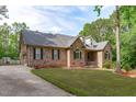 Well-maintained brick home with a lush green lawn, black shutters, and mature trees at 1016 Luminary Ln, Willow Springs, NC 27592