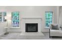 Bright living room featuring a fireplace, large windows and plush chair at 107 Long Shadow Ln, Cary, NC 27518