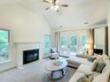 Living room with white fireplace, vaulted ceiling, and access to the outdoor deck at 107 Long Shadow Ln, Cary, NC 27518