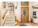 Bright foyer with wood trim, an elegant front door, and a staircase with carpeted steps at 108 Hanover Pl, Chapel Hill, NC 27516