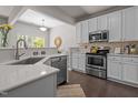 Modern kitchen featuring white cabinets, stainless steel appliances, quartz countertops and dark wood flooring at 110 Huntersville Rd, Morrisville, NC 27560