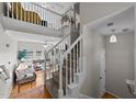 Bright entryway with hardwood floors, a staircase with white railings, and a view of the living room at 11013 Louson Pl, Raleigh, NC 27614