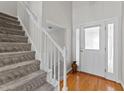 Bright foyer boasts hardwood floors, a frosted glass front door, and carpeted stairs at 11013 Louson Pl, Raleigh, NC 27614