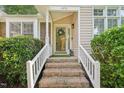 Inviting entryway featuring a wreath on the glass front door with brick stairs and white railing at 1102 Laurens Way, Knightdale, NC 27545