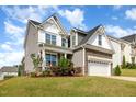 Charming two-story home with manicured lawn and a stone-accented two-car garage at 111 Laporte Path, Garner, NC 27529