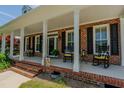Charming front porch with rocking chairs and brick columns creating a welcoming entryway at 114 Fieldstone Dr, Burlington, NC 27215