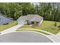 A beautiful single-story home with a manicured lawn on a cul-de-sac with mature trees at 1304 Essex Skipper Way, Fuquay Varina, NC 27526