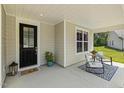 Cozy front porch featuring a 'Hello' welcome mat, seating, and a well-lit entry with a glass panel door at 1304 Essex Skipper Way, Fuquay Varina, NC 27526