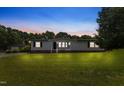 Inviting one-story home with freshly mowed lawn, vinyl siding, and warm exterior lighting at 165 Dawn Rd, Benson, NC 27504
