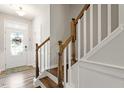 Bright entryway features wood floors and a staircase with white risers and wood railing at 174 Walking Path Pl, Hillsborough, NC 27278