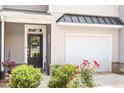 Inviting front entrance with black front door, garage, and manicured landscaping at 174 Walking Path Pl, Hillsborough, NC 27278