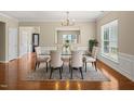 The dining room has a glass table, six chairs, a rug, and hardwood floors at 204 Dowington Ln, Cary, NC 27519