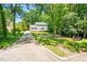 Traditional home with a long driveway surrounded by lush trees and an inviting, verdant lawn at 2107 Somers Ave, Burlington, NC 27215
