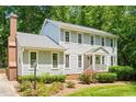 Classic two-story home boasts a brick chimney, landscaped garden beds, and a welcoming front porch at 2107 Somers Ave, Burlington, NC 27215