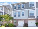 Stylish townhome featuring a brick facade, two-car garage, and neutral-toned siding for a modern look at 217 Jones Hill Rd, Holly Springs, NC 27540