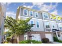 Stylish townhome featuring a brick facade, two-car garage, and neutral-toned siding for a modern look at 217 Jones Hill Rd, Holly Springs, NC 27540