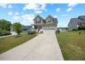Inviting two-story home with a well-manicured lawn and a long concrete driveway at 225 Alcock Ln, Youngsville, NC 27596