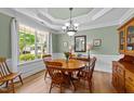 Bright dining room featuring a round wooden table, matching chairs, large window, and traditional wainscoting details at 232 Shady Hollow Ln, Garner, NC 27529