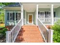 Inviting front porch with brick steps, white railings, and a beautiful wooden front door at 2408 Fordcrest Dr, Apex, NC 27502