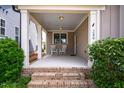 Inviting covered porch with rocking chairs, brick steps, and elegant columns at 249 Salt Cedar Ln, Chapel Hill, NC 27516