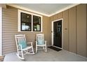 Cozy porch with rocking chairs and a stylish dark front door at 249 Salt Cedar Ln, Chapel Hill, NC 27516
