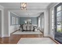 Elegant dining room featuring wainscoting, a modern chandelier, and seating for eight, perfect for Gathering gatherings at 2711 Jordan Pointe Blvd, New Hill, NC 27562