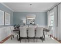 Dining room with a modern chandelier, seating for eight, and large windows that offer ample natural light at 2711 Jordan Pointe Blvd, New Hill, NC 27562
