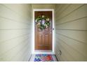 Inviting front door with a decorative wreath and colorful welcome mat at 3034 Winfred Dell Ln, Cary, NC 27511