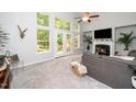Spacious living room with fireplace and backyard views through large windows and french doors at 3034 Winfred Dell Ln, Cary, NC 27511