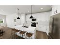 Modern kitchen features white cabinets, stainless steel appliances, and a quartz countertop island with seating at 309 Beacon Dr, Pittsboro, NC 27312