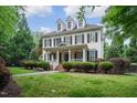 Charming two-story home with black shutters, dormers, front porch and professionally landscaped yard at 3325 Falls River Ave, Raleigh, NC 27614