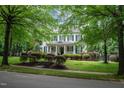 Charming two-story home with black shutters, brick front steps, and professionally landscaped yard at 3325 Falls River Ave, Raleigh, NC 27614