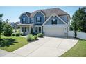 Two-story home with a long driveway, two car garage, manicured lawn, blue siding and a front porch at 3536 Greenville Loop Rd, Wake Forest, NC 27587