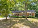 Cozy brick home with a well-maintained lawn, accented by mature trees and a classic design at 4119 Toroella St, Durham, NC 27704