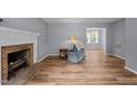 Cozy living room with a brick fireplace, hardwood floors, and ample natural light at 4119 Toroella St, Durham, NC 27704