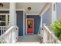 A covered front porch with white pillars, a red door, and house number 450 on a blue house at 450 Granite Mill Blvd, Chapel Hill, NC 27516