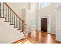 Grand foyer with hardwood floors, high ceilings, and a staircase with iron railings at 5520 Creek Pine Dr, Wake Forest, NC 27587