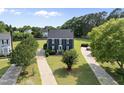 Aerial view of charming two-story home with a manicured lawn, black shutters, and a bright green front door at 6 W Canterbury Ct, Wendell, NC 27591