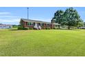 Lovely brick home featuring a well-manicured lawn and mature trees offering curb appeal at 6080 Us 421 N, Lillington, NC 27546