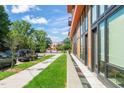 Street view of a modern condo building with large windows and well-maintained landscaping at 615 Daniels St # 215, Raleigh, NC 27605