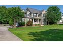 Charming two-story home with a well-manicured lawn and inviting front porch at 8140 Consella Way, Willow Springs, NC 27592