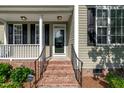 Inviting front porch with black railings, brick steps, and classic architectural details at 8140 Consella Way, Willow Springs, NC 27592