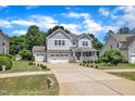 Charming two-story home with a well-manicured lawn and long driveway leading to an attached two-car garage at 85 Clubhouse Dr, Youngsville, NC 27596