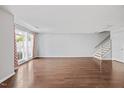 Bright and airy living room boasting beautiful hardwood floors and access to the outdoors through a glass door at 8630 Neuse Landing # 105, Raleigh, NC 27616