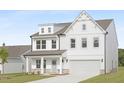 Beautiful two-story home boasts a crisp white facade, an attached two-car garage, and manicured lawn at 88 Mable Court # 17, Lillington, NC 27546